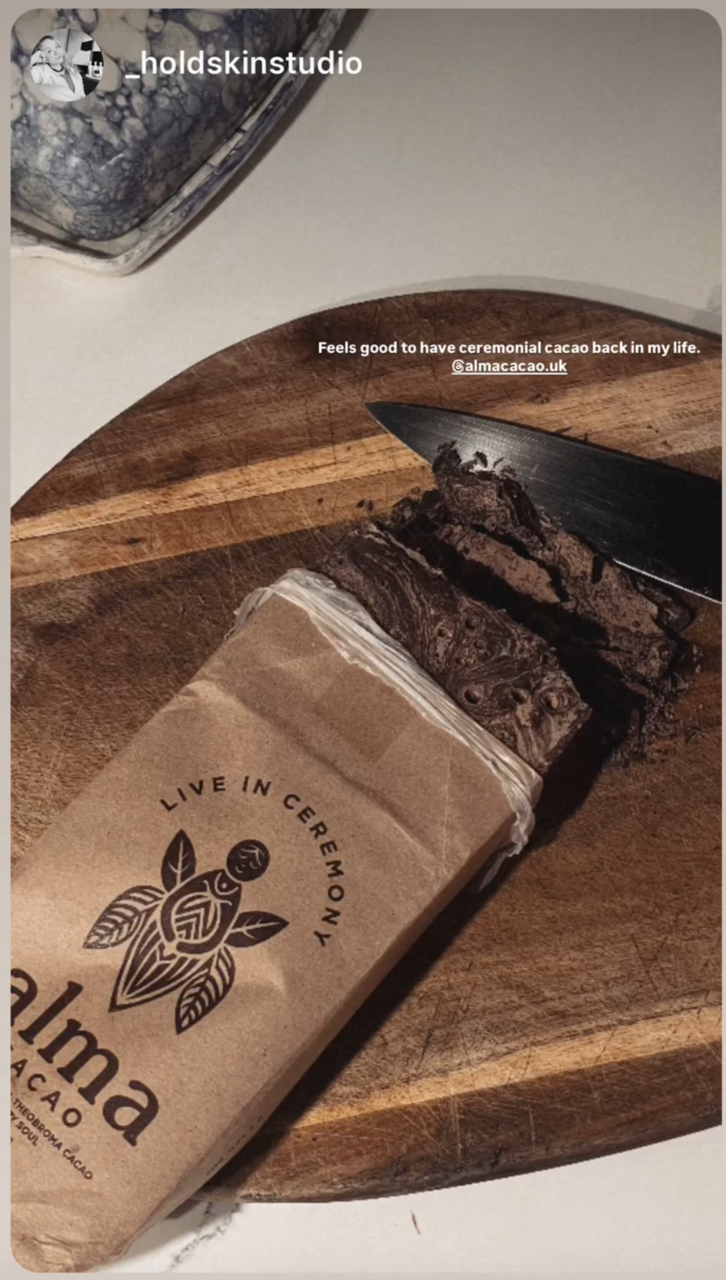 Cacao bar on a wooden cutting board with a knife, branded 'Alma Cacao'. UGC Review