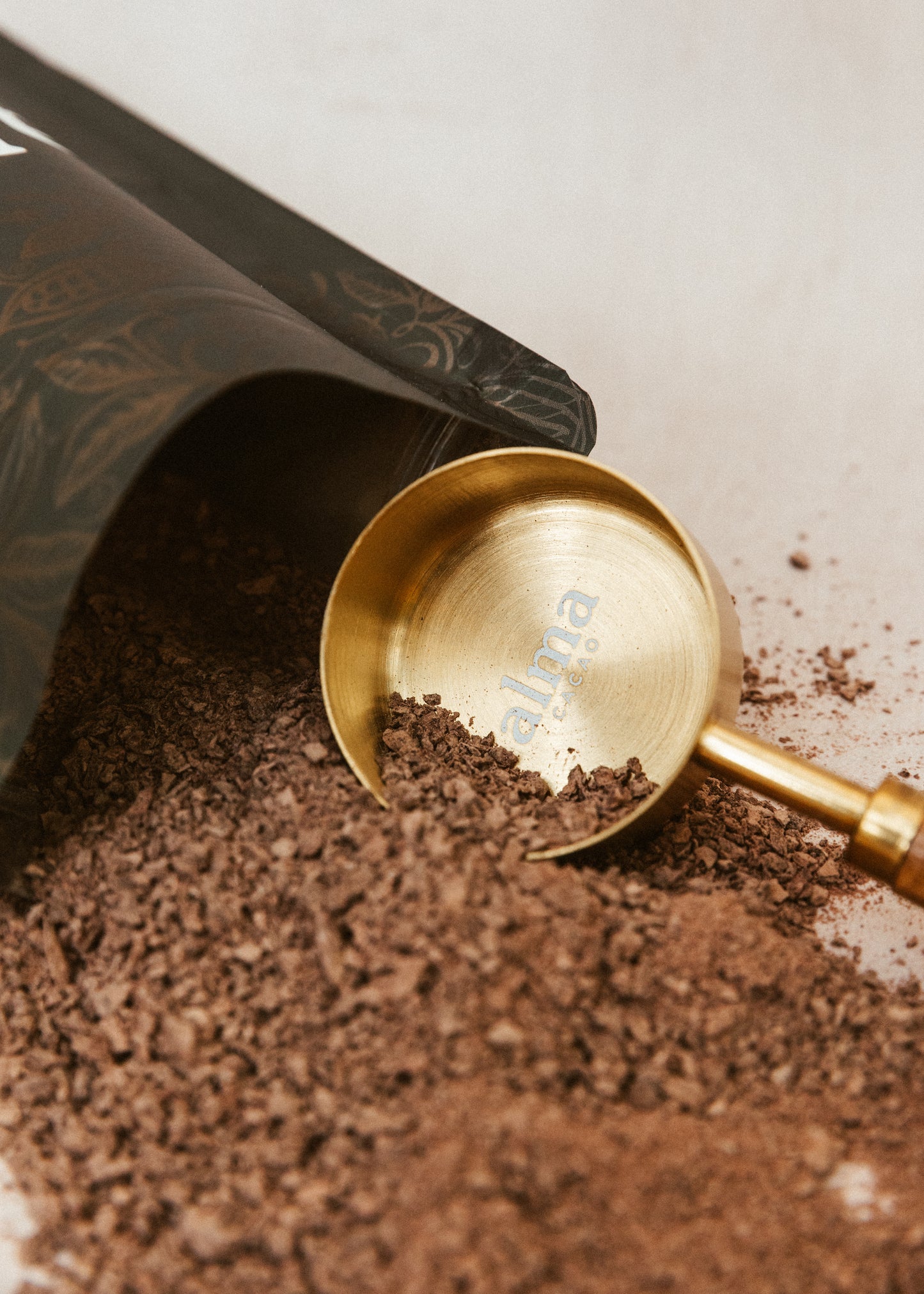 Gold cacao scoop in a container of grated cacao
