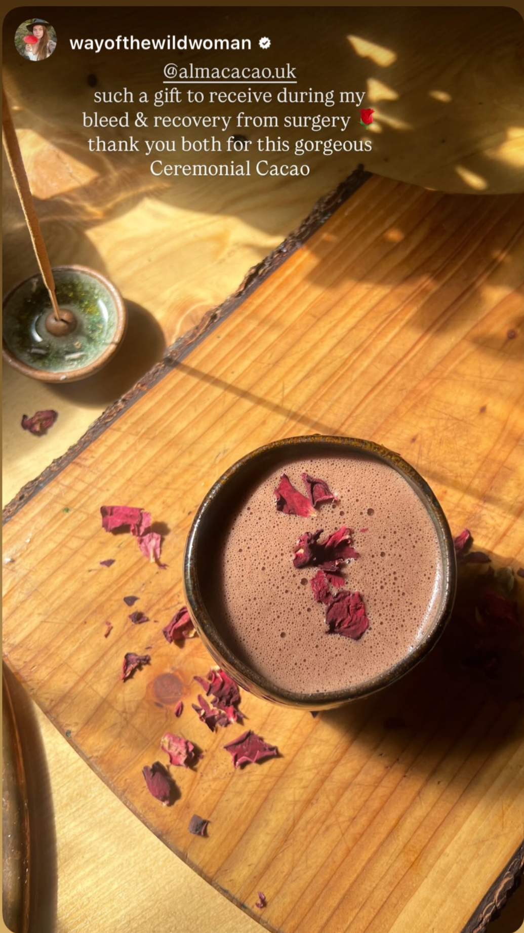 Ceremonial cacao with dried flowers on a wooden surface, surrounded by incense